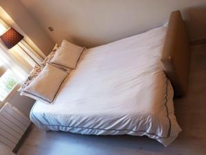 - un lit avec des draps et des oreillers blancs dans l'établissement Madrid Las Tablas apartments, à Madrid