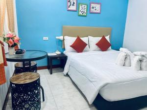 a blue room with a bed and a table at Lanta Grand House in Ko Lanta