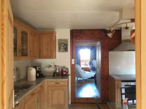 a kitchen with wooden cabinets and a counter top at Les Quatre Saisons - balcon et jardin in Val-d'Illiez