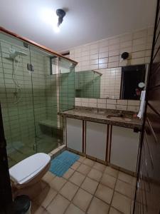 a bathroom with a toilet and a glass shower at HostellHouse Márcia Guimarães in João Pessoa