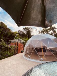 una sombrilla grande en la parte superior de un patio en GLAMPING EL PARAÍSO, en Sasaima