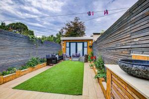 a backyard with a green lawn in front of a house at Luxurious House Leyton sleep7+garden next to Stratford in London