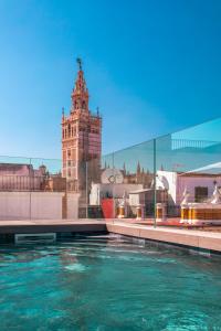 a pool of water in front of a clock tower at Casa Alhaja by Shiadu in Seville