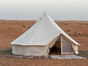 a white tent in the middle of the desert at Thousand Stars Desert Camp in Badīyah