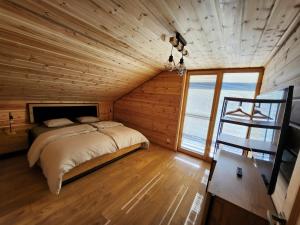 a bedroom with a bed in a wooden house at Chalet Fiona with jacuzzi in Mýto pod Ďumbierom