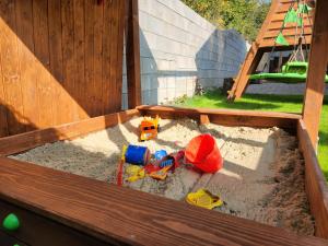a wooden sandbox with toys in the sand at Chalet Fiona with jacuzzi in Mýto pod Ďumbierom