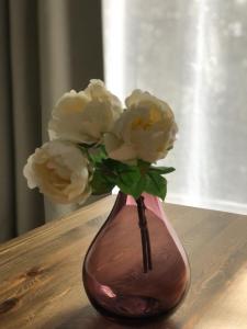wazon z białymi kwiatami na stole w obiekcie Doamvid Universidad w mieście Ciudad Real