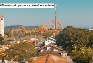 uma montanha-russa num parque com árvores e edifícios em Savanna Suites - Beto Carrero em Penha