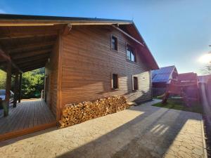 a barn with a pile of fire wood on the side at Chalet Fiona with jacuzzi in Mýto pod Ďumbierom