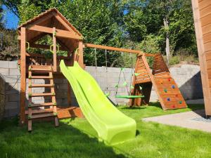 a playground with a slide and a play structure at Chalet Fiona with jacuzzi in Mýto pod Ďumbierom