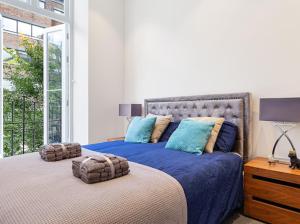 um quarto com uma cama grande e almofadas azuis em Harley Street Luxury Snug em Londres