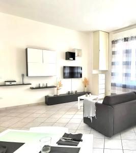 a living room with a couch and a tv at White Home Forli Centro in Forlì +7 photos