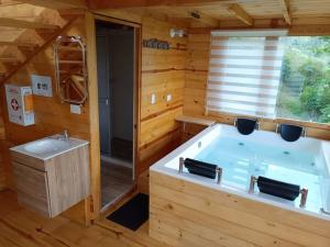 - une salle de bains avec une grande baignoire dans une maison en bois dans l'établissement Ecocabaña con Jacuzzi Ecocabañas ByB, à Choachí