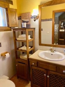 uma casa de banho com um lavatório e um espelho em La Casita de Chocolate - CASA rural en el Bierzo em Ponferrada