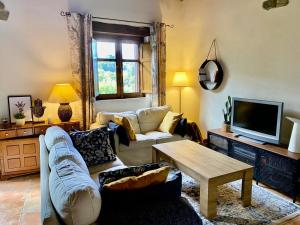 uma sala de estar com um sofá e uma mesa em La Casita de Chocolate - CASA rural en el Bierzo em Ponferrada