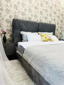een bed met een grijs hoofdeinde in een slaapkamer bij Mega Tower Almaty with beautiful moutain views in Alma-Ata