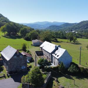 een luchtfoto van een huis in een veld bij Lodge-Sagne une ferme rénovée au cœur du Cantal à proximité de la station de ski du Lioran 