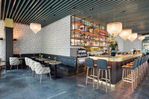 a restaurant with a bar with chairs and tables at Bright & Central Studio Home Office & Netflix in Zurich