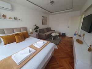 - une chambre avec un grand lit et un canapé dans l'établissement Stan na dan Golden apartman, à Zaječar