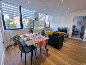 a living room with a table and a couch at Free Parking: Old Trafford Apartment in Manchester