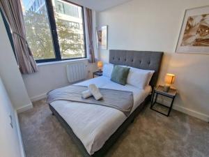 a bedroom with a large bed with two lamps on tables at Free Parking: Old Trafford Apartment in Manchester