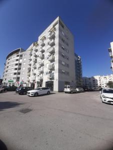 a large building with cars parked in a parking lot at Apartment Relax with infrared Sunshower in Varaždin