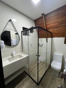 a bathroom with a shower and a sink and a toilet at Hotel e Cabanas Perau CABANAS in Ametista do Sul