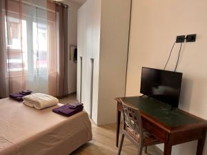 een slaapkamer met een bed en een bureau met een televisie bij Gold sand in Cagliari