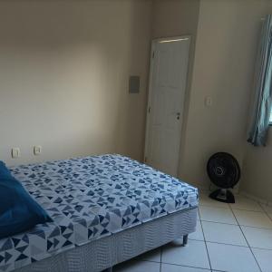 a bedroom with a bed with a blue and white comforter at Casa Jardim Belvedere VR in Volta Redonda +1 photo