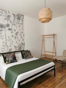 a bedroom with a bed with a green blanket at Appartement La palette in Villers-Semeuse