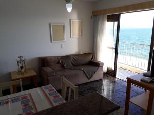 sala de estar con sofá y vistas al océano en Lexus Beira Mar - Apartamentos, en Florianópolis