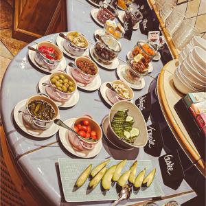 einen Tisch mit Teller mit Lebensmitteln und Schalen mit Früchten in der Unterkunft Hotel Reiler Hof in Reil