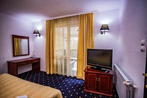 Cette chambre comprend un lit et une télévision à écran plat. dans l'établissement Casa Octavian, à Suceviţa