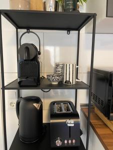 a shelf with a coffee maker and a microwave at -Bella Casa- Central Studio Apartment in Fürth