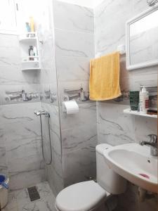 a white bathroom with a toilet and a sink at Chambre calme et relaxante à centre ville Agadir in Agadir