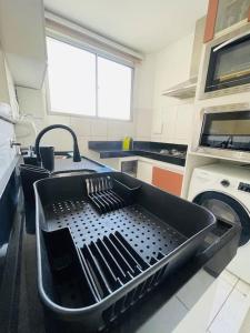 a kitchen with a sink and a black dishwasher at 1º Ap decorado do GALO em frente à ARENA MRV in Belo Horizonte