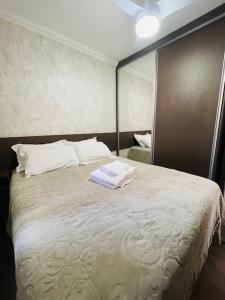 a bedroom with a large bed with a mirror at 1º Ap decorado do GALO em frente à ARENA MRV in Belo Horizonte