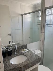 a bathroom with a sink and a toilet and a mirror at 1º Ap decorado do GALO em frente à ARENA MRV in Belo Horizonte