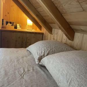 a bed with white sheets and a window in a room at Chalet Skidh - 10 personnes - emplacement idéal au centre de Vaujany in Vaujany