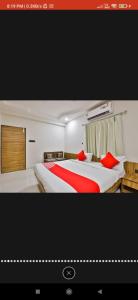 2 camas en una habitación de hotel con almohadas rojas en HOTEL SURYAKANT, en Rajkot