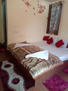 two beds in a room with flowers on the wall at New natraj in Chikalda