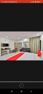 HOTEL SURYAKANT في راجكوت: غرفة نوم كبيرة بها سرير وتلفزيون
