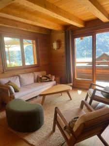 a living room with a couch and a table at Chalet Skidh - 10 personnes - emplacement idéal au centre de Vaujany in Vaujany