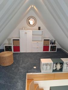 a attic room with white cabinets and a table at Klein, aber fein in Sophienhof +5 photos