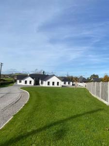 a house with a grassy yard next to a road at Ard na Gréine in Stradbally