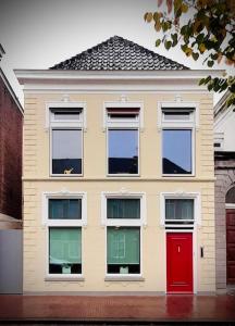 a house with four windows and a red door at bij DE RODE DEUR in Meppel