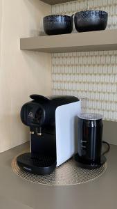 eine Kaffeemaschine auf einem Regal mit Tassen in der Unterkunft bij DE RODE DEUR in Meppel