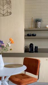 a table and a chair next to a table and a shelf at bij DE RODE DEUR in Meppel