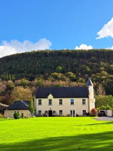 una gran casa blanca en un campo verde en Glangwili Mansion - Luxury 5 star Bed & Breakfast, en Carmarthen