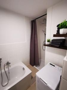 ein Badezimmer mit einer weißen Badewanne und einem Waschbecken in der Unterkunft Zentral und ruhig in Chemnitz in Chemnitz